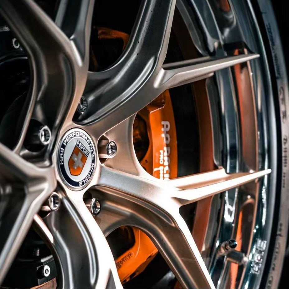 Close-up of a bmw wheel with a prominent hre logo on the rim, after the installation of titanium wheel lug bolts