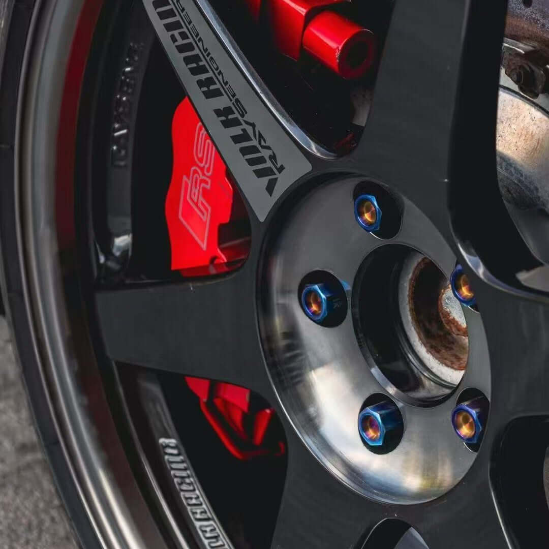 Close-up of a car wheel with red brake caliper and 'R&S Racing' branding, after the installation of blue titanium wheel lug bolts in Aumotor Australia customer feeback